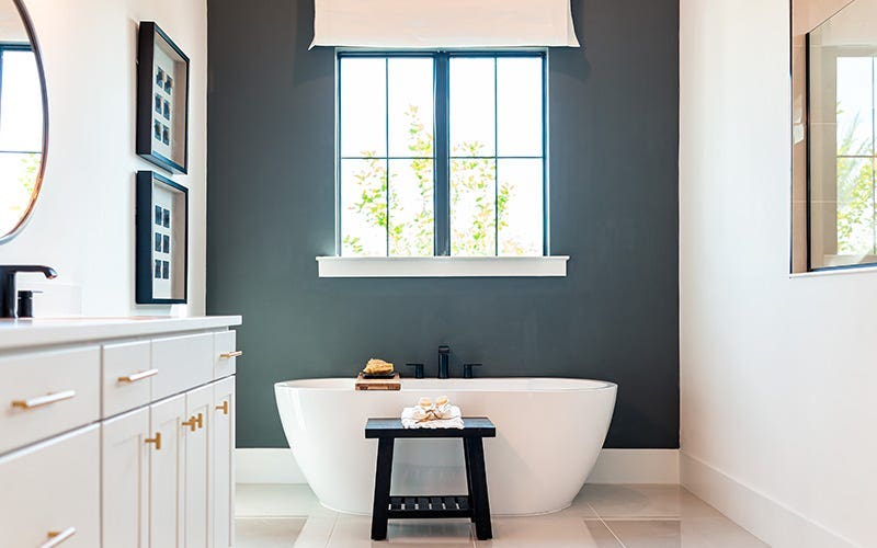 Une salle de bain spacieuse avec une baignoire élégante et un lavabo élégant, conçu pour le confort et la détente.
