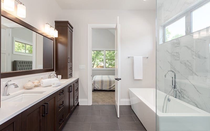 Salle de bain moderne avec une grande douche à l'italienne et un double évier, conçu pour la fonctionnalité et l'élégance.