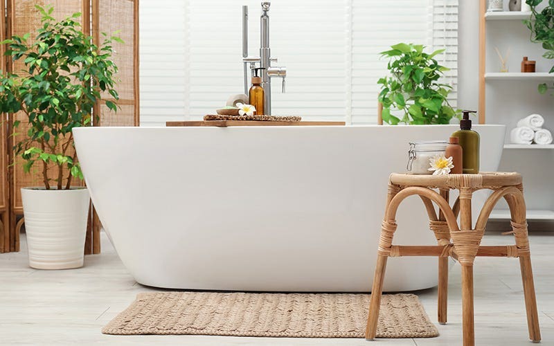 Une baignoire blanche lumineuse accompagnée d'un tabouret, améliorant la fonctionnalité et le style de la salle de bain