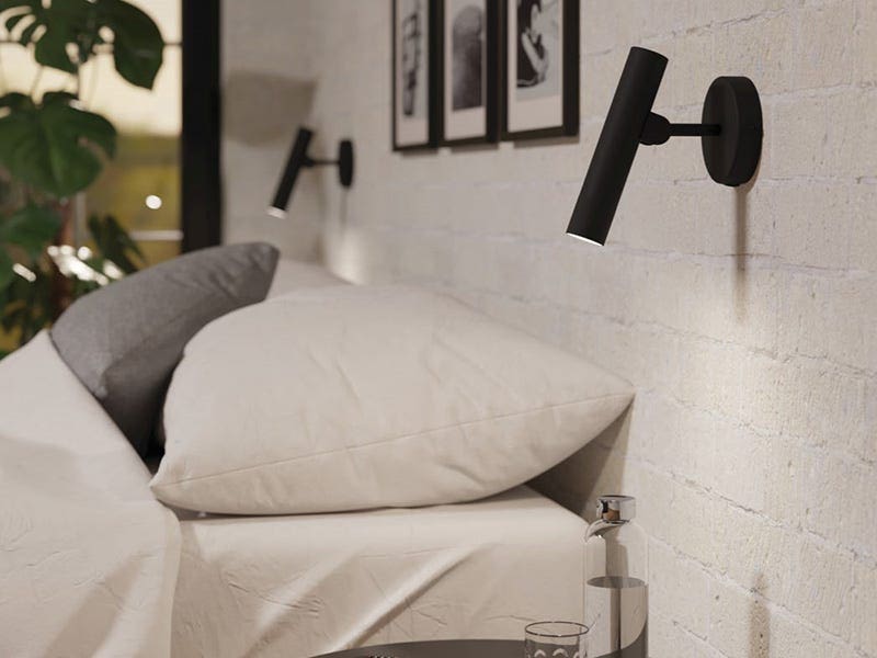 Cozy bedroom with two black cylindrical wall-mounted reading lights