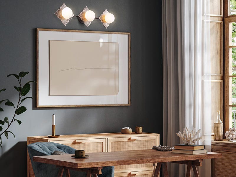 Contemporary workspace with three-bulb decorative wall light above artwork