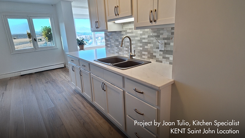 A modern kitchen featuring white cabinets and a stainless steel sink, creating a bright and clean atmosphere.